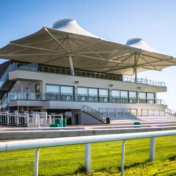 Phot of the main grandstand at Bath Racecourse on a clear day.